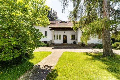 Noblesní prvorepubliková vila zvenčí s okolní zelení.