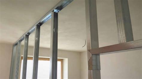 Detailní pohled na montáž kovové konstrukce pro sádrokartonové příčky.
