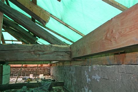 architekt detailně prohlíží starý stropní trám