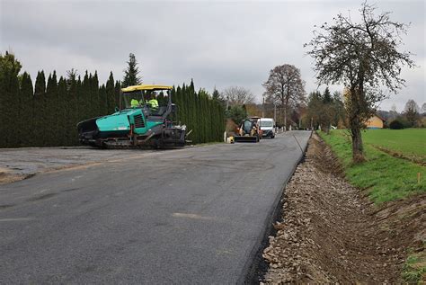Fotografie rekonstruovaného úseku silnice s těžkou technikou a stavebními materiály