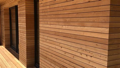 Detail fasády apartmánového domu s použitím sibiřského modřínu a tmavých materiálů