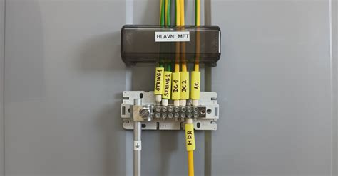 Detailní záběr na svorkovnici pro hlavní uzemňovací svorku (MET) s připojenými vodiči.