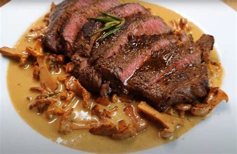 Detailní záběr na hovězí steak s omáčkou a přílohou.
