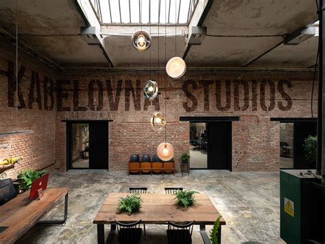 Interiér industriálního prostoru Kabelovna Studios s odhalenými cihlovými zdmi a vysokými stropy.