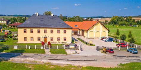 Malebná krajina Beskyd s budovami Apartmánů Na Faře a Stodoly Na Bílé